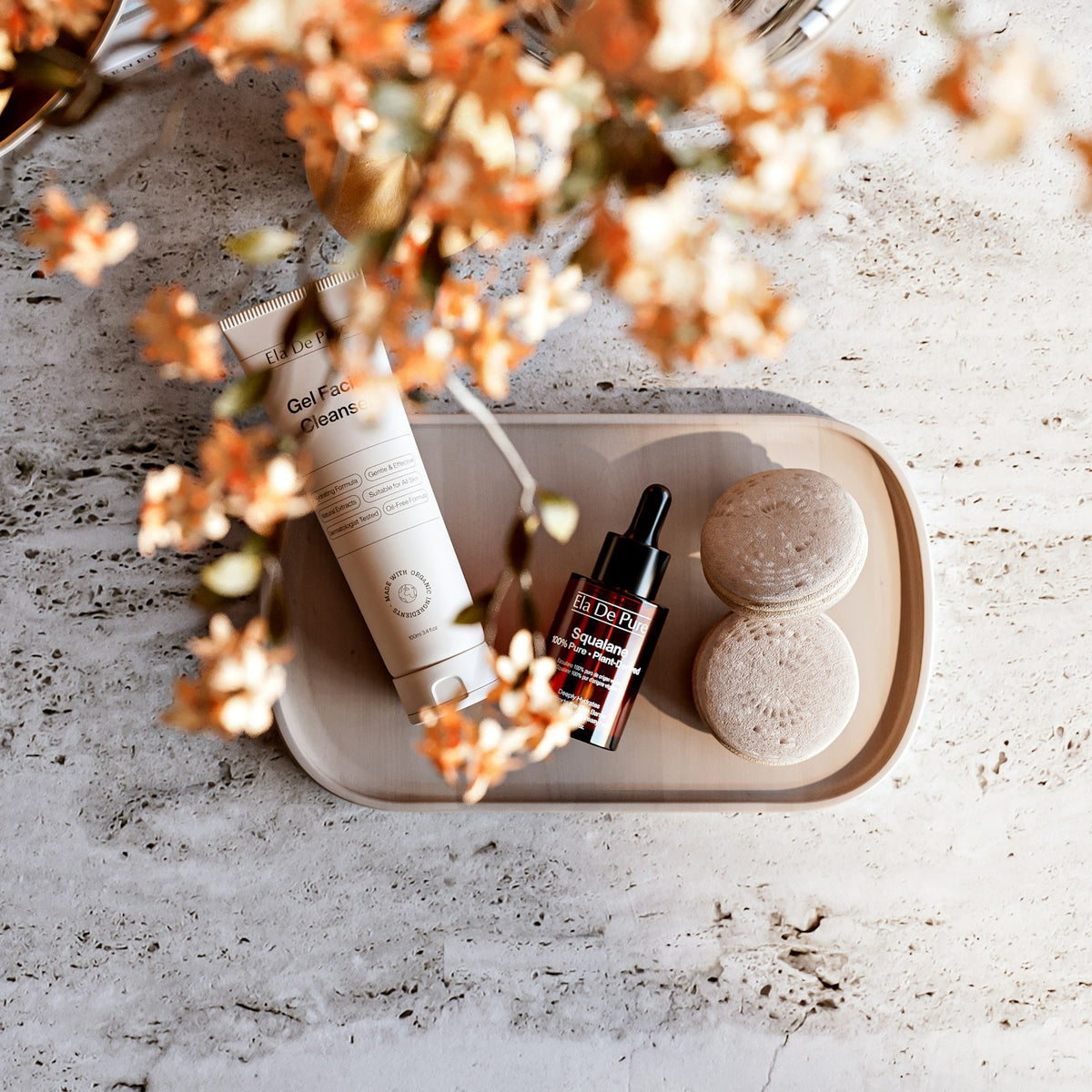 Cleanser, serum and sponges set on a tray